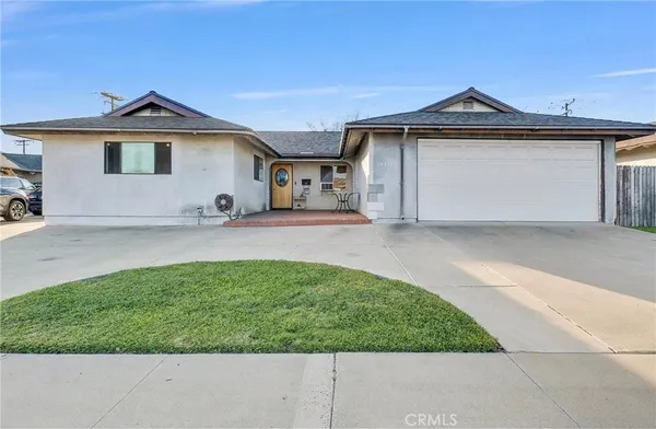 a front view of a house with a garden and yard