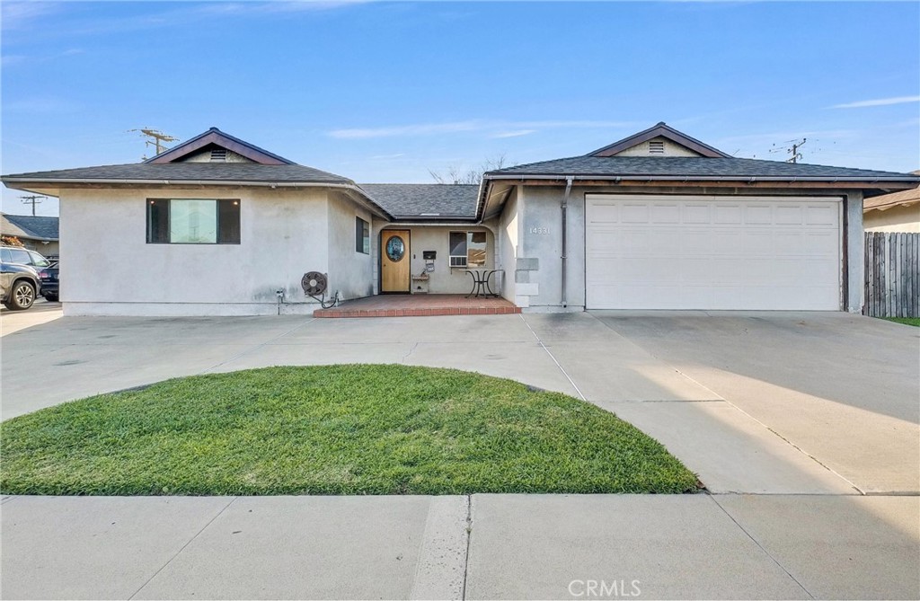 a front view of a house with a garden and yard