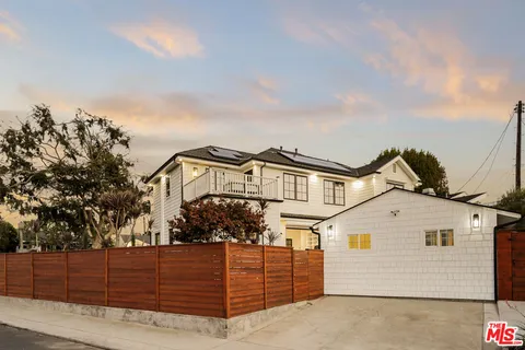 a front view of a house with wooden fence