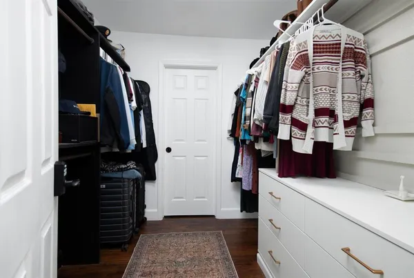 a view of walk in closet with clothes and shoes