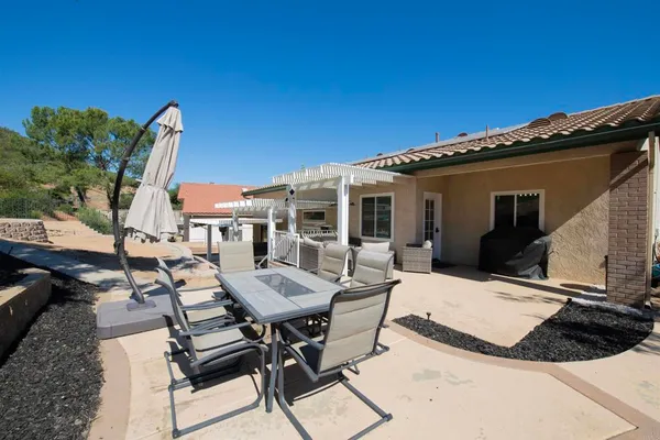 a view of a dinning table and chairs in patio of the house