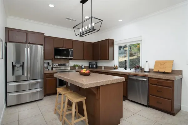 a kitchen with stainless steel appliances granite countertop a sink stove and refrigerator