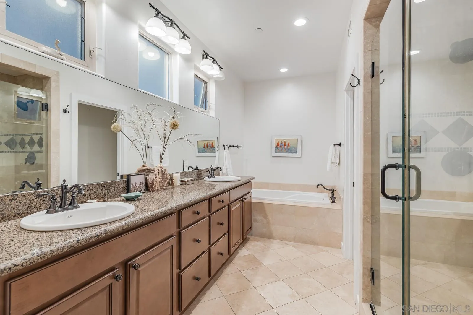 2009 MacKinnon Avenue Cardiff, CA 92007 - Photo 22 of 54 a bathroom with a granite countertop sink a mirror a bathtub and shower