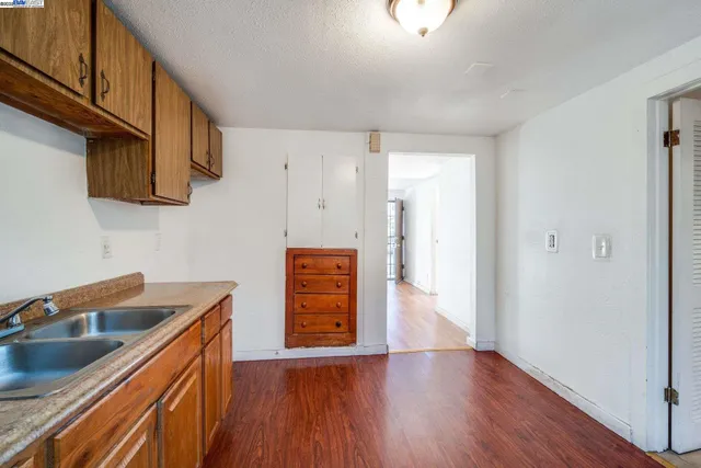 a kitchen with stainless steel appliances granite countertop a sink a stove and a wooden floors