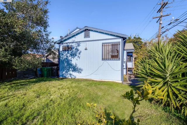 a view of a white house with a big yard and large trees