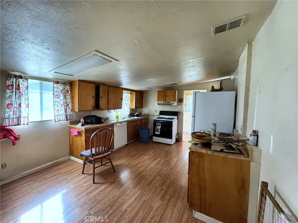 a kitchen that has a sink chairs and wooden floor