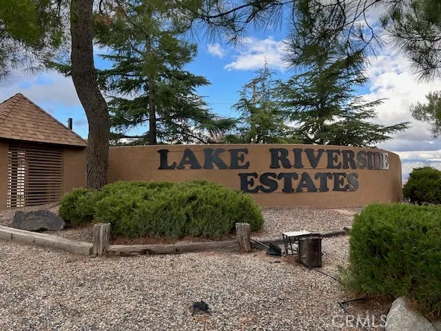 a view of a brick house with a yard and large tree