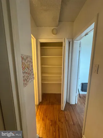 a view of walk in closet with wooden floor