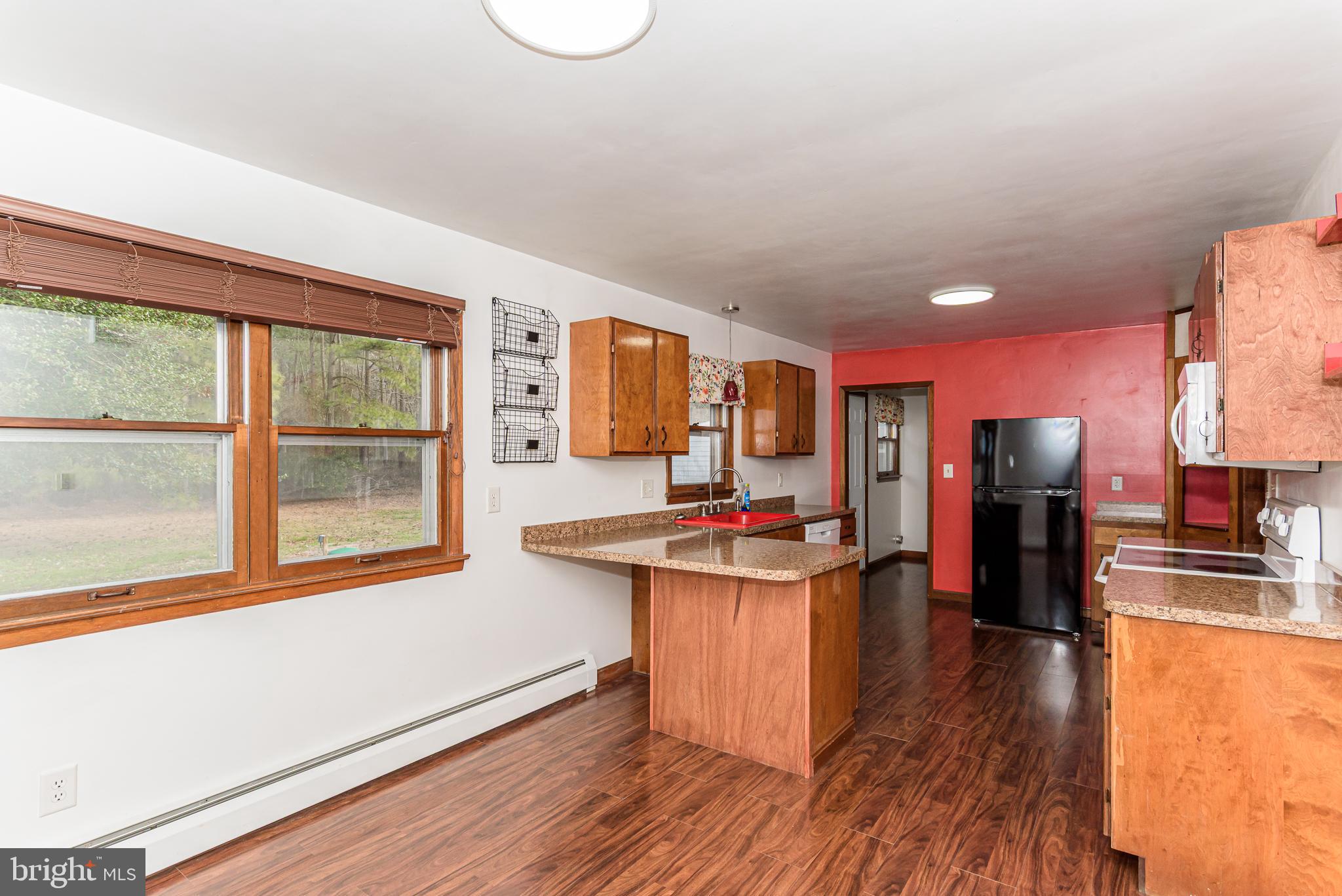 1745 Buck Harbor Road Pocomoke City, MD 21851 - Photo 11 of 29 a kitchen with stainless steel appliances granite countertop a stove and wooden floor