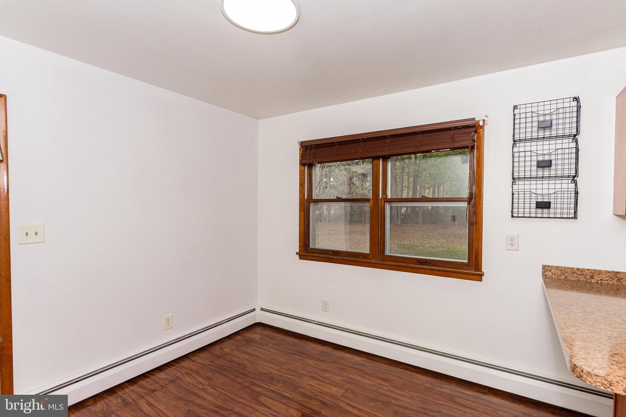 1745 Buck Harbor Road Pocomoke City, MD 21851 - Photo 12 of 29 a view of an empty room with wooden floor and a window