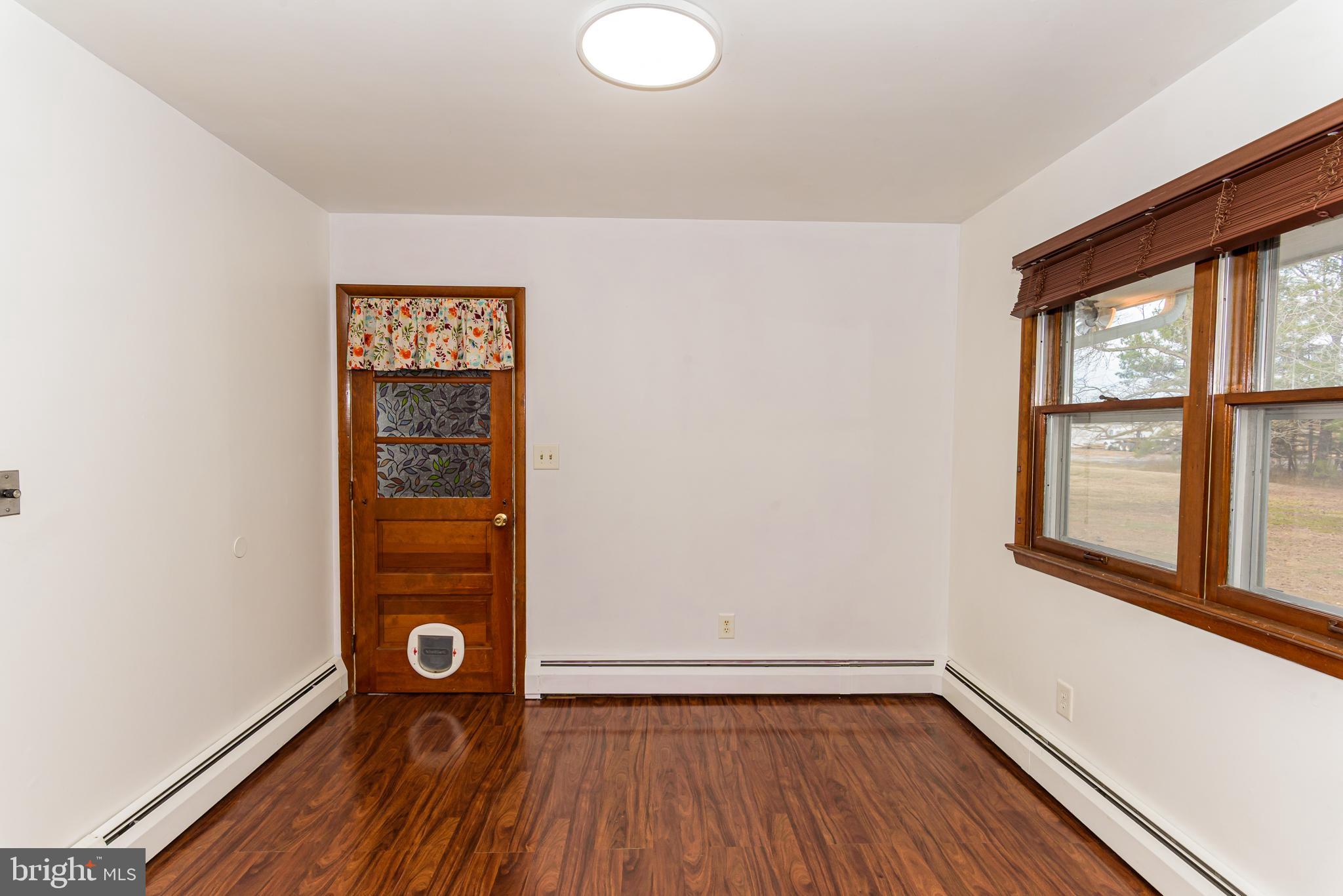 1745 Buck Harbor Road Pocomoke City, MD 21851 - Photo 13 of 29 an empty room with wooden floor and windows