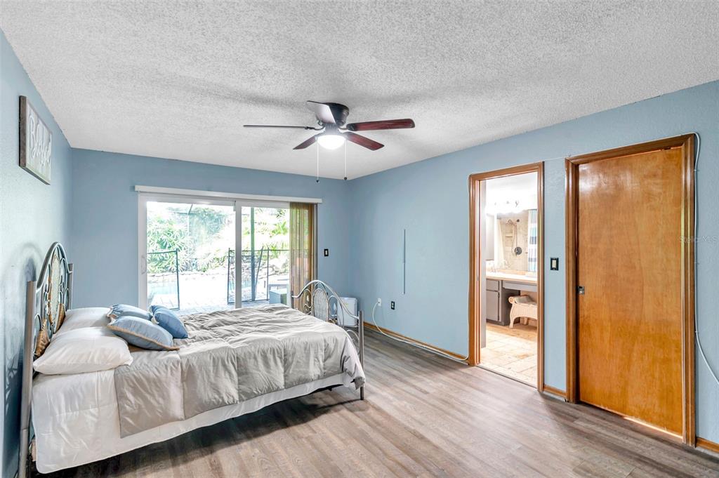 11334 Redgate Street Spring Hill, FL 34609 - Photo 11 of 67 a spacious bedroom with a bed and a ceiling fan