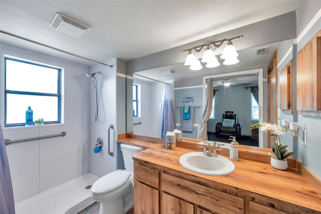 11334 Redgate Street Spring Hill, FL 34609 - Photo 15 of 67 a bathroom with a granite countertop double vanity sink toilet mirror and window