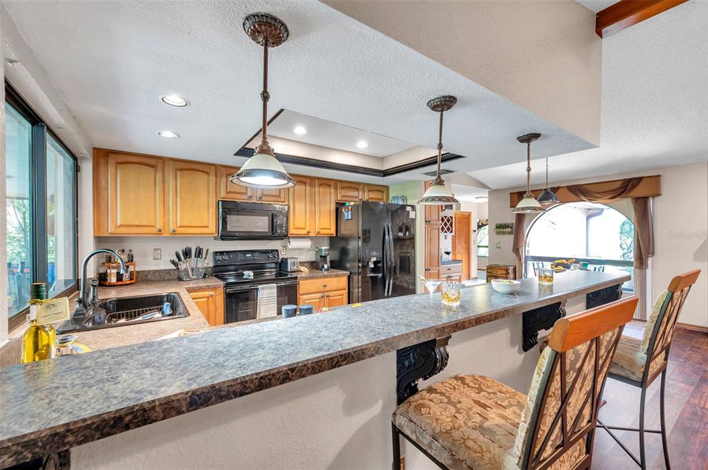 11334 Redgate Street Spring Hill, FL 34609 - Photo 44 of 67 a kitchen with stainless steel appliances granite countertop a sink a stove and a wooden floors