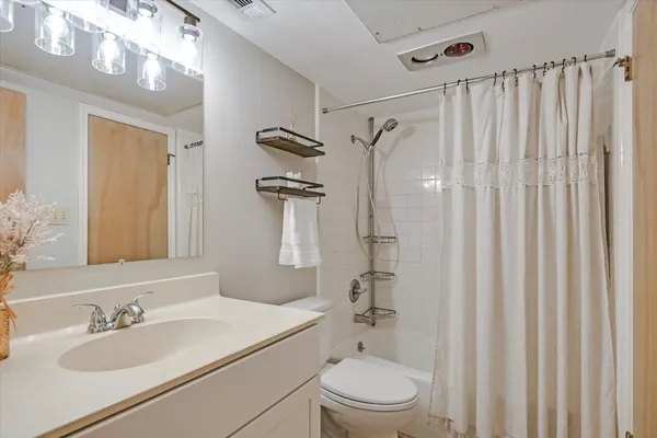 a bathroom with a sink a toilet and shower curtain