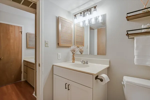 a bathroom with a sink a toilet and a mirror