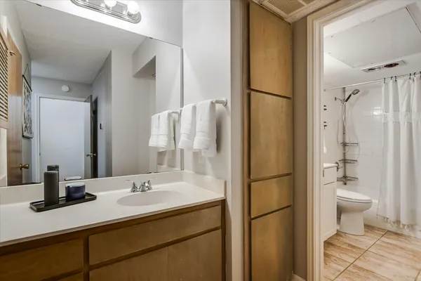 a bathroom with a sink toilet a mirror and shower