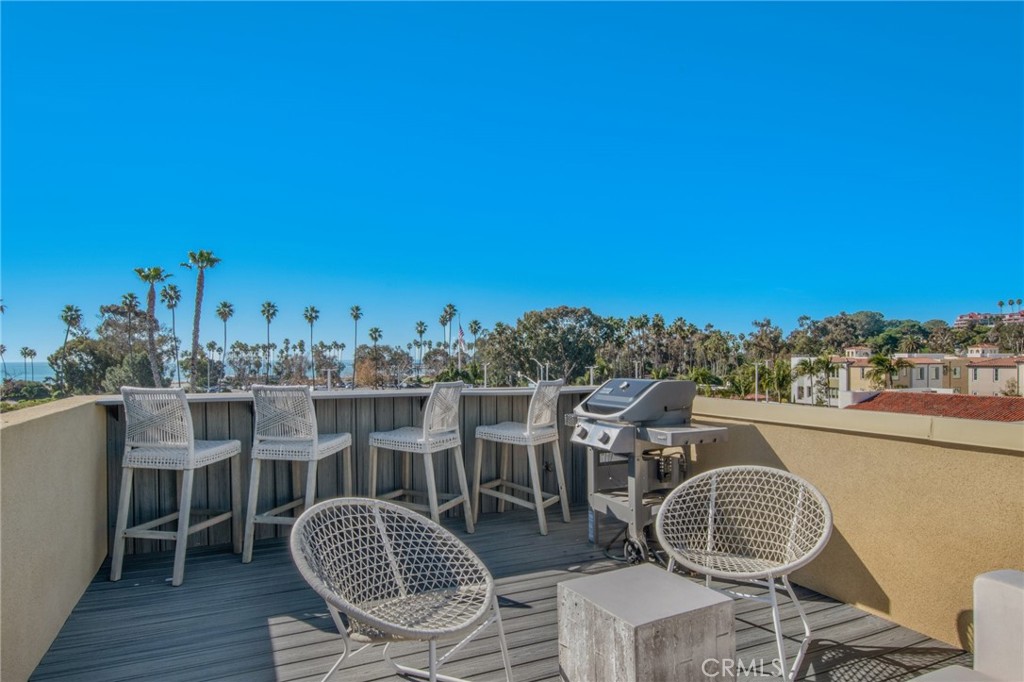 a view of roof deck with table and chairs