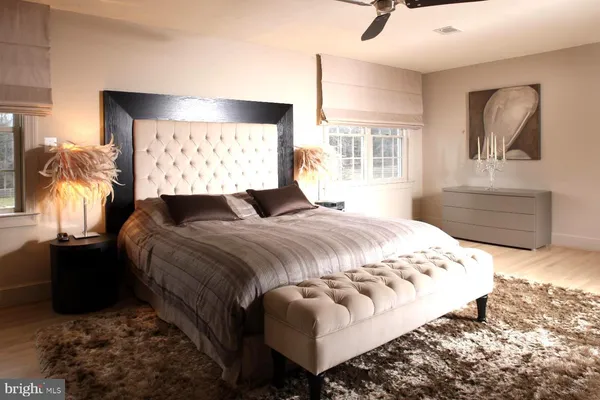 a bedroom with a bed and dresser with mirror
