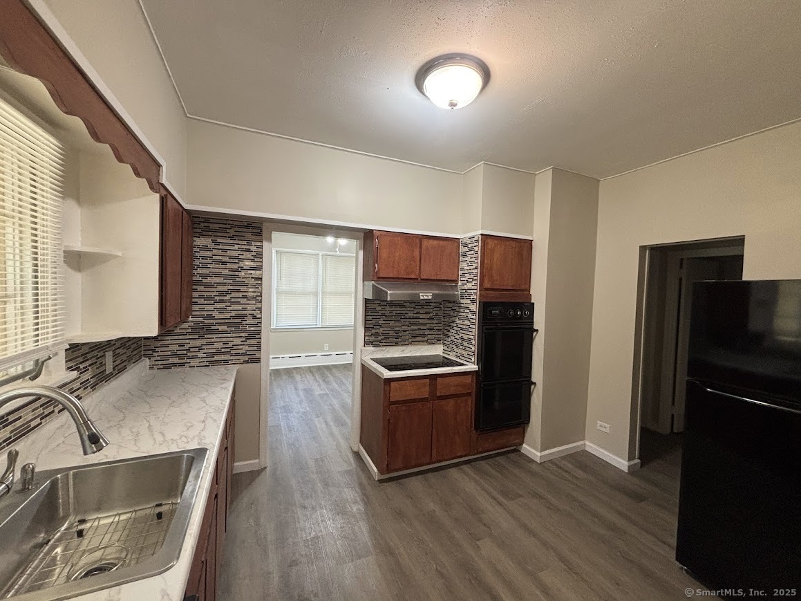 a kitchen with granite countertop a refrigerator stove and sink