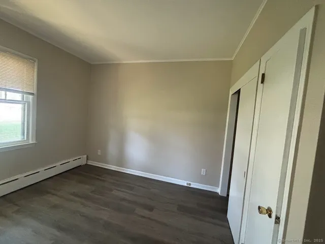 an empty room with wooden floor and window