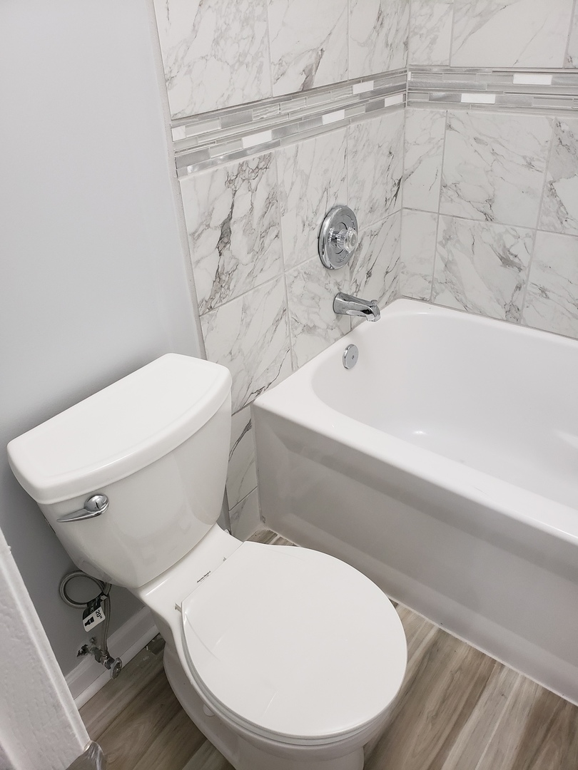 55 Willow Road Matteson, IL 60443 - Photo 15 of 37 a white toilet sitting next to a bath tub and a sink