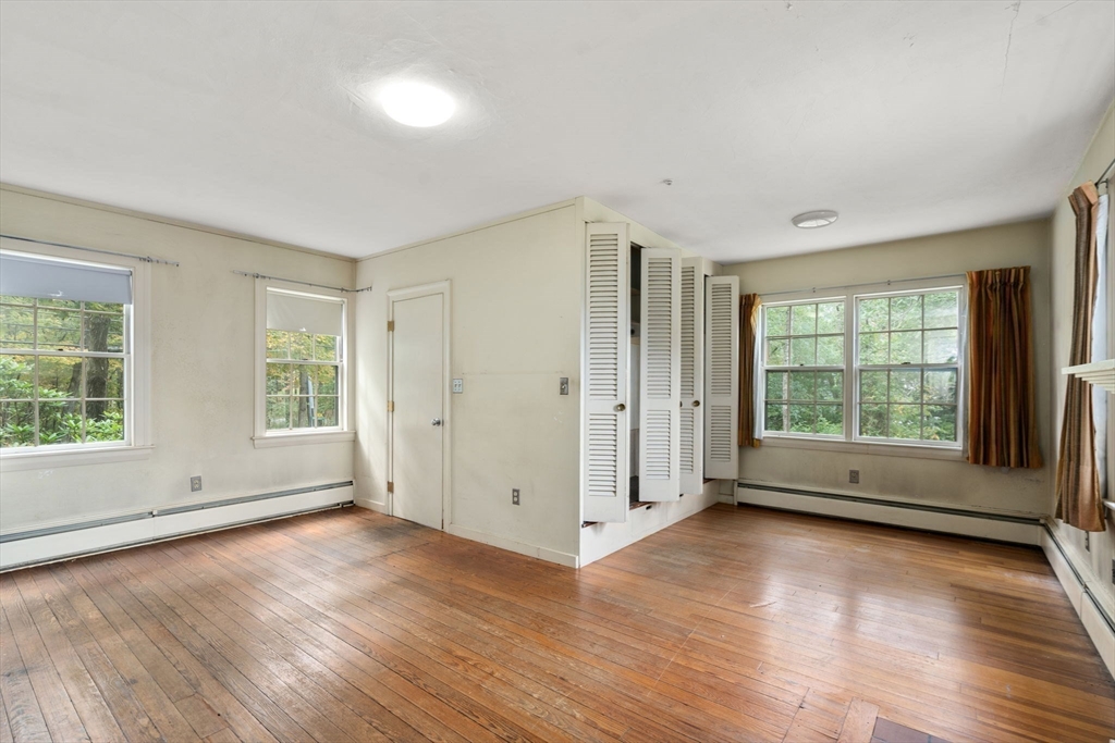145 Tower Road Lincoln, MA 01773 - Photo 12 of 26 an empty room with wooden floor and windows