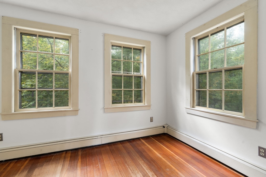 145 Tower Road Lincoln, MA 01773 - Photo 15 of 26 an empty room with wooden floor and windows