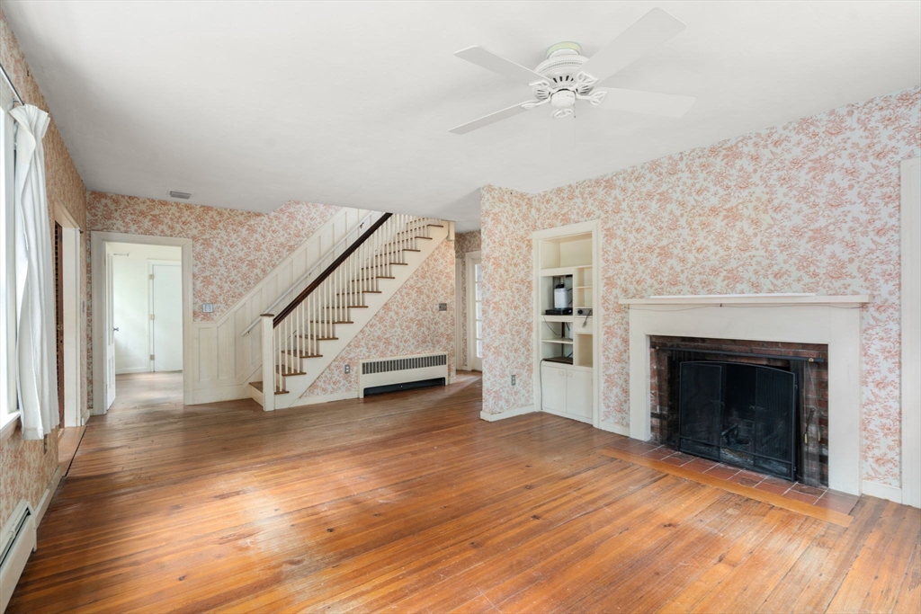 145 Tower Road Lincoln, MA 01773 - Photo 2 of 26 a view of an empty room with wooden floor fireplace and a chandelier