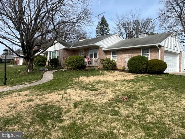 a view of a house with a yard and large tree