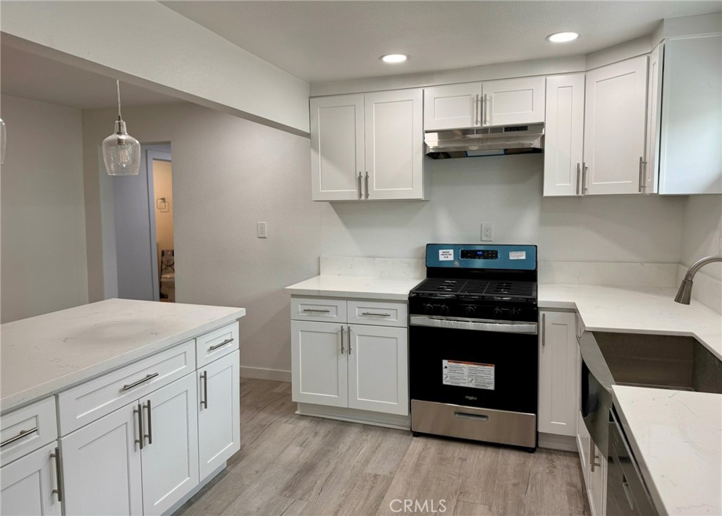 1362 South Downey Road Los Angeles, CA 90023 - Photo 13 of 30 a kitchen with white cabinets and appliances