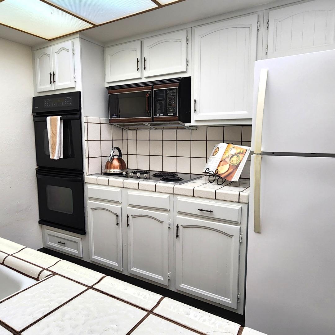 1500 Broadway, Unit 205 Burlingame, CA 94010 - Photo 8 of 24 a kitchen with stainless steel appliances a refrigerator sink and microwave