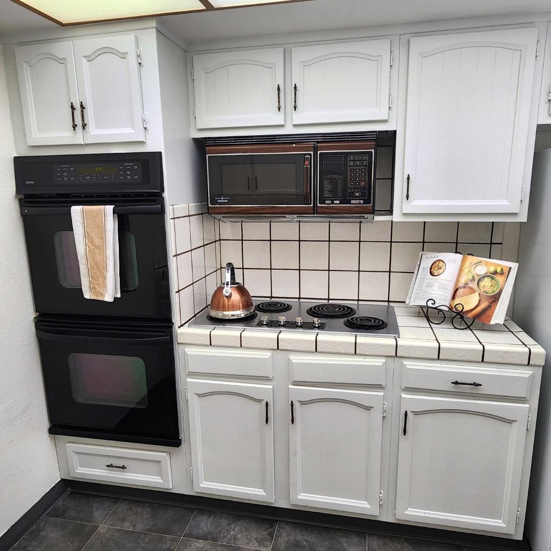 1500 Broadway, Unit 205 Burlingame, CA 94010 - Photo 9 of 24 a kitchen with granite countertop white cabinets and appliances