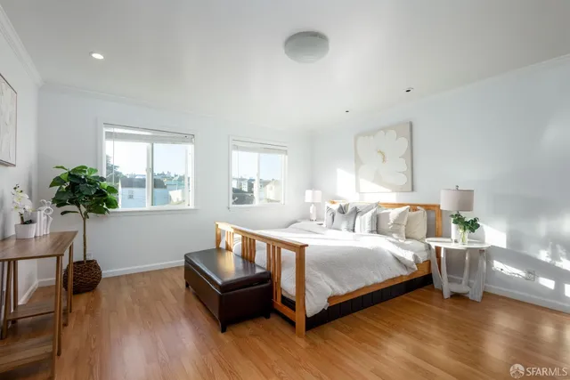 a bedroom with a bed and a potted plant on table
