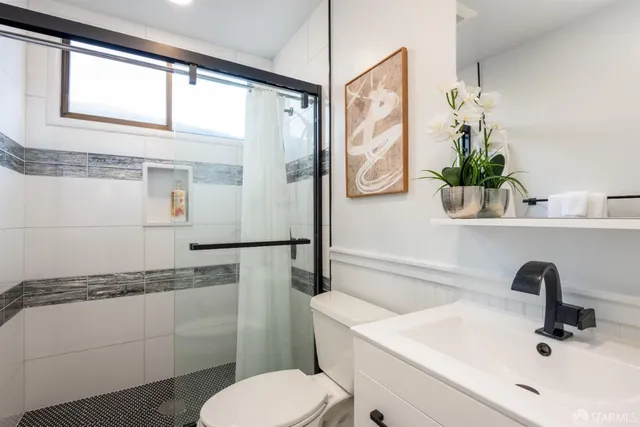 a bathroom with a sink a toilet and a mirror