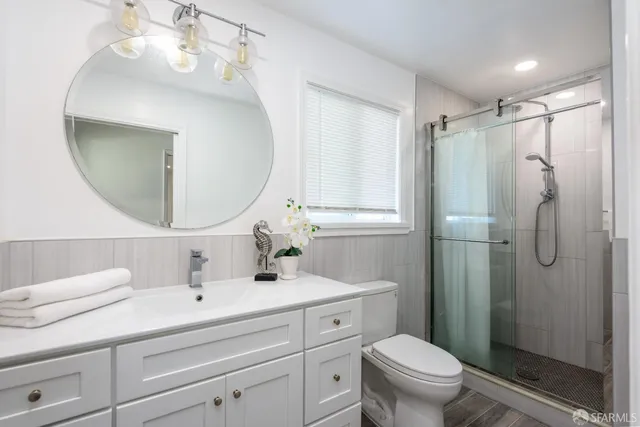 a bathroom with a sink a toilet and shower