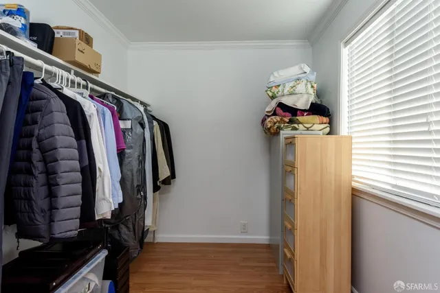 a view of walk in closet with clothes and shoes
