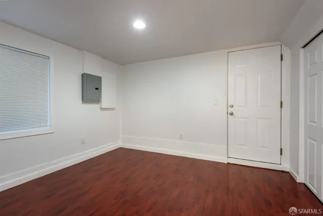 a view of an empty room with wooden floor