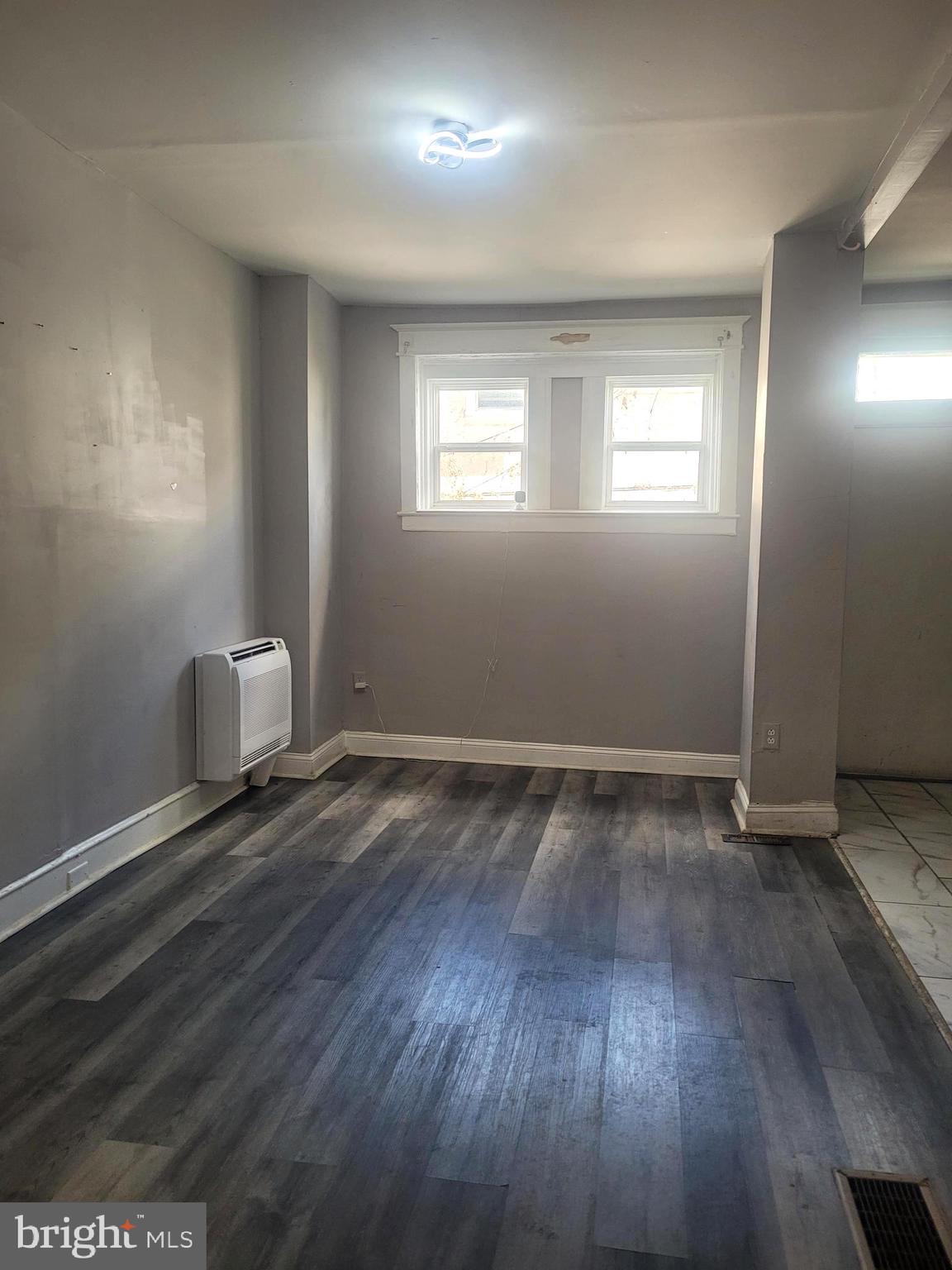 5563 Blakemore Street Philadelphia, PA 19138 - Photo 3 of 14 an empty room with wooden floor and windows