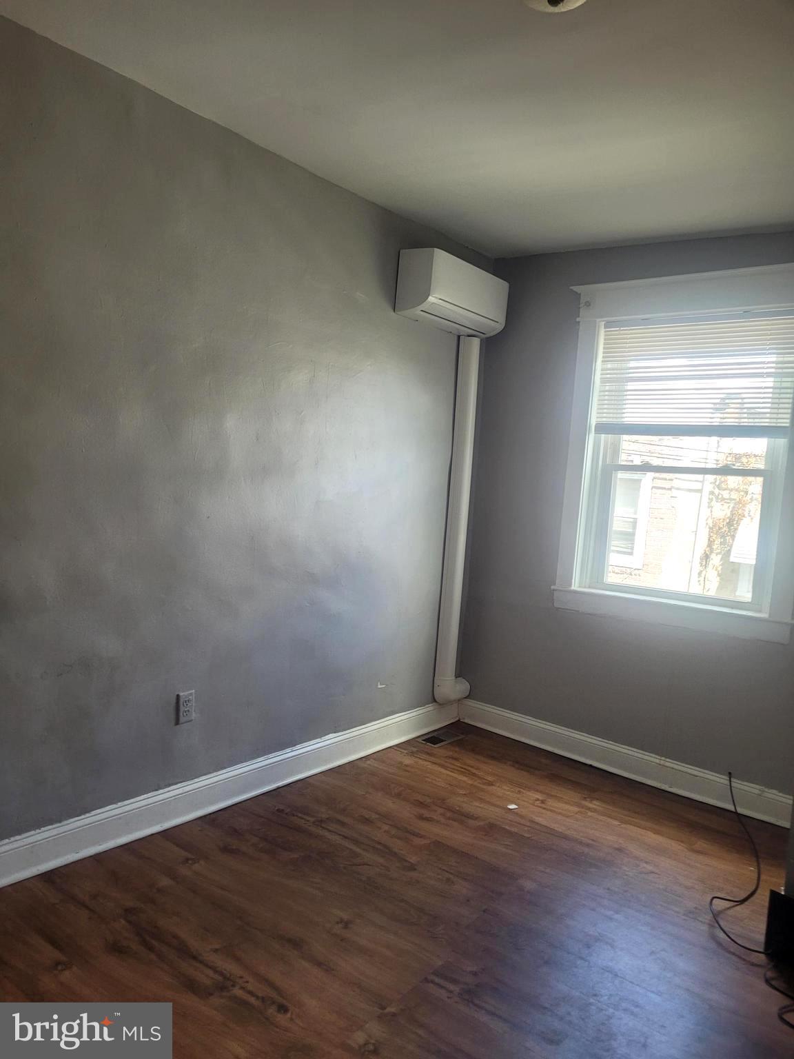5563 Blakemore Street Philadelphia, PA 19138 - Photo 4 of 14 an empty room with wooden floor and windows