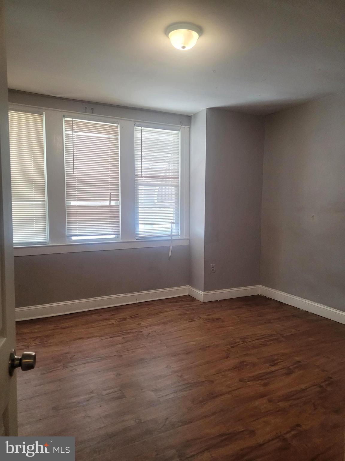 5563 Blakemore Street Philadelphia, PA 19138 - Photo 9 of 14 an empty room with wooden floor and windows
