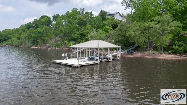 a view of a lake with a table and chairs under an umbrella