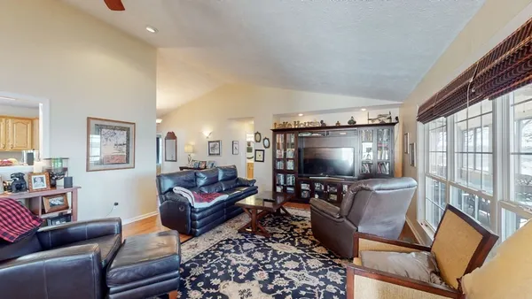 a living room with furniture a flat screen tv and a window