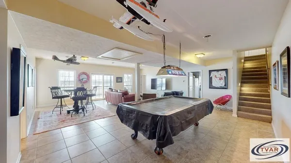 a dining hall with couches a dining table and chairs with wooden floor