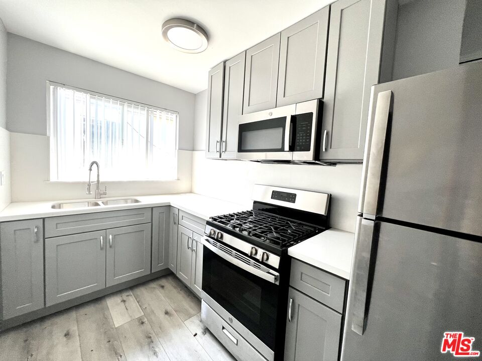4025 Palmyra Road, Unit 1 Los Angeles, CA 90008 - Photo 3 of 5 a kitchen with granite countertop a sink stove and refrigerator