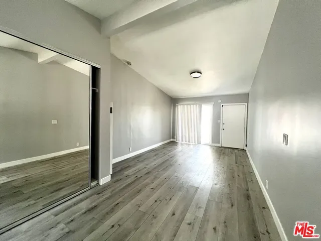 a view of an empty room with wooden floor