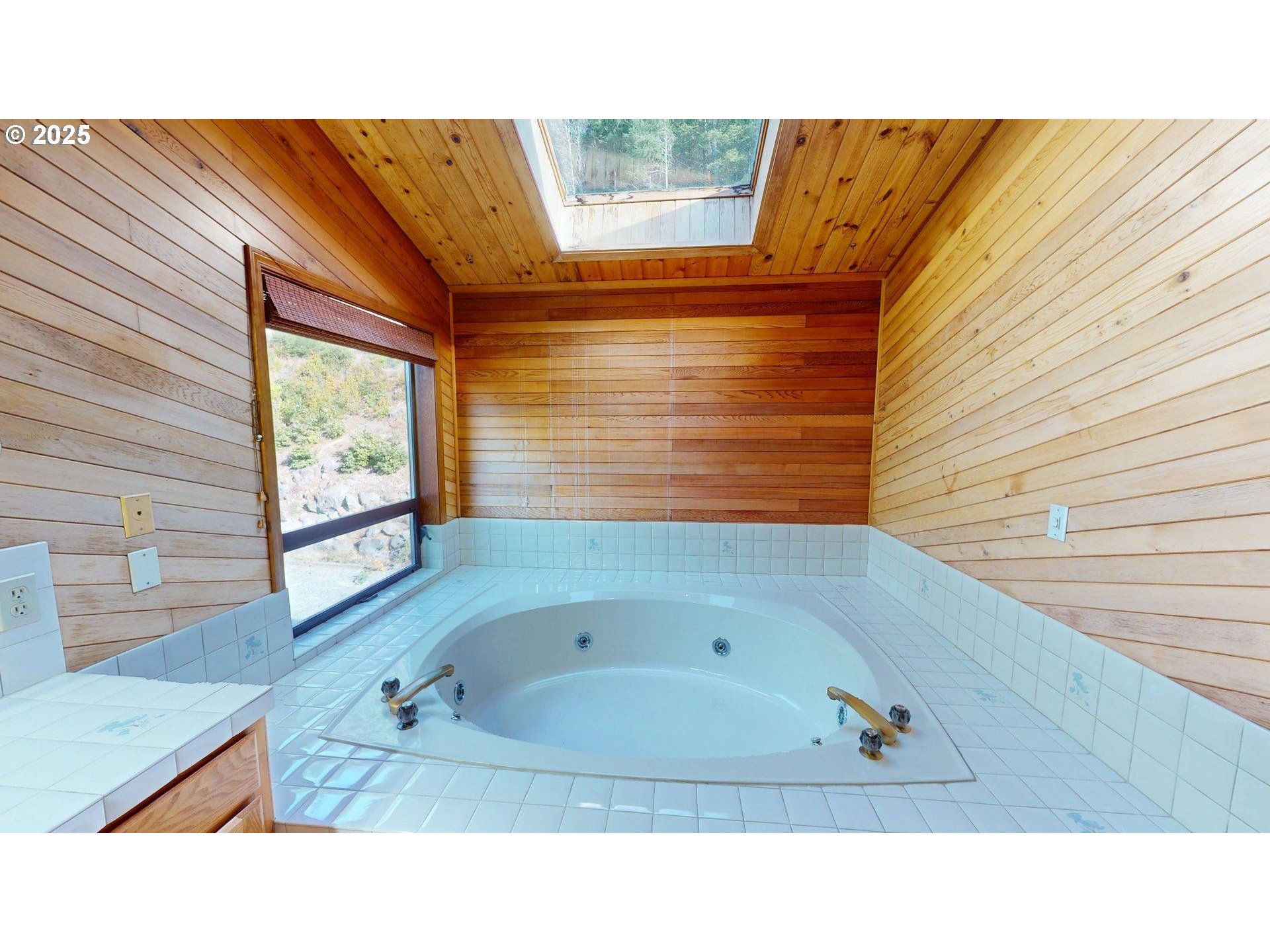 95107 Welsh Drive Gold Beach, OR 97444 - Photo 19 of 48 a bathroom with a sink a bathtub and next to a window