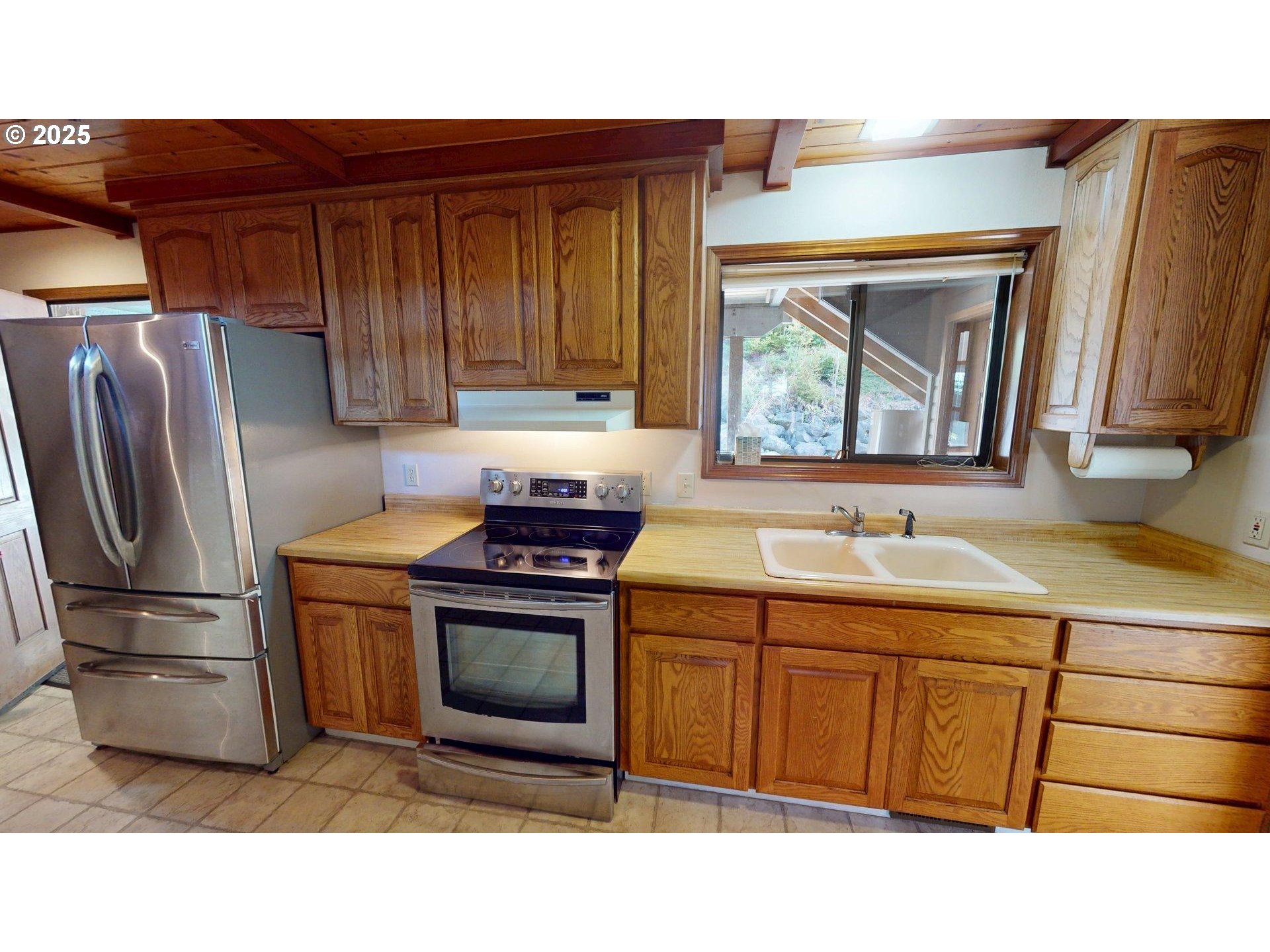 95107 Welsh Drive Gold Beach, OR 97444 - Photo 22 of 48 a kitchen with stainless steel appliances a stove a sink and a refrigerator