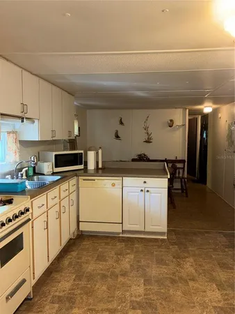 a kitchen with granite countertop a sink a stove and cabinets