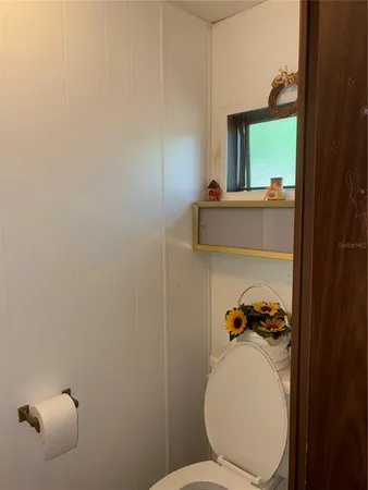 a bathroom with a toilet and a mirror